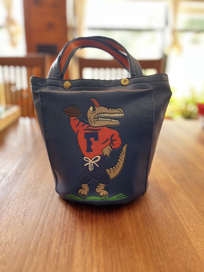 Blue vinyl Gators bucket purse with painted Albert holding a football, front