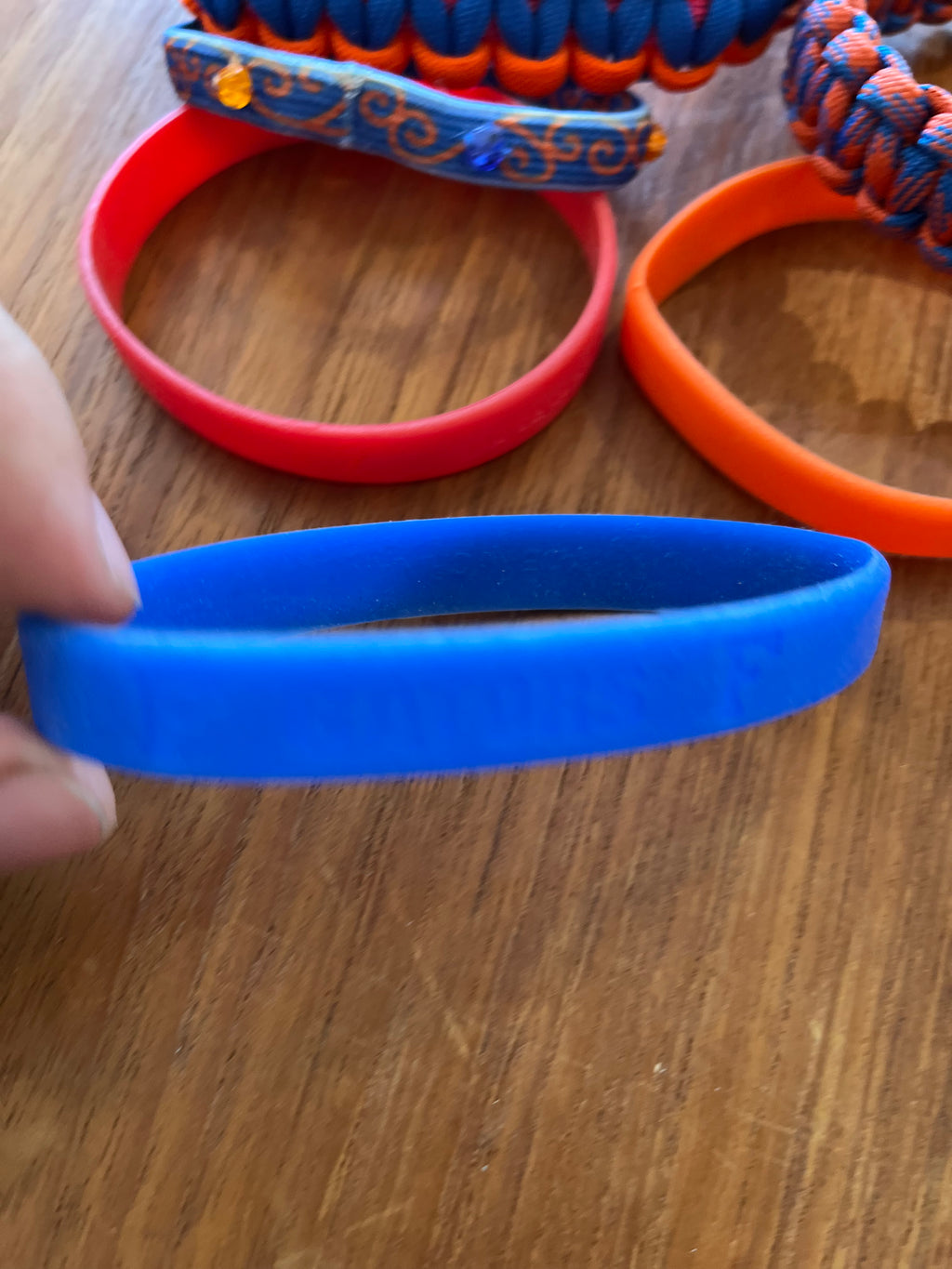 Blue silicone band close-up with other bracelets behind