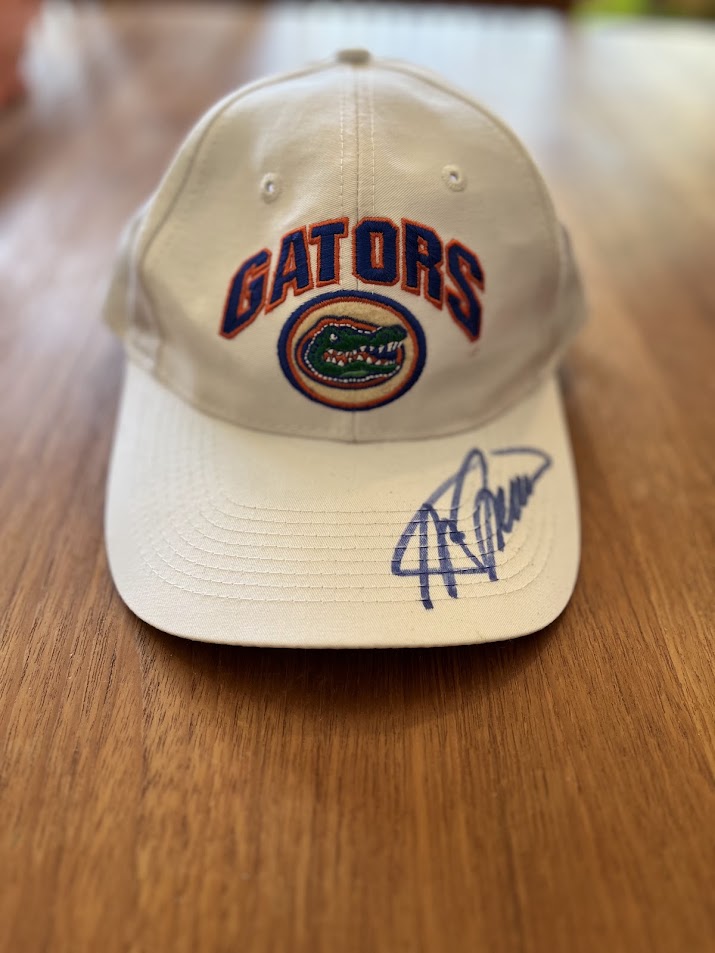 White Top of the World Gators arch cap with blue-ink signature on bill, front