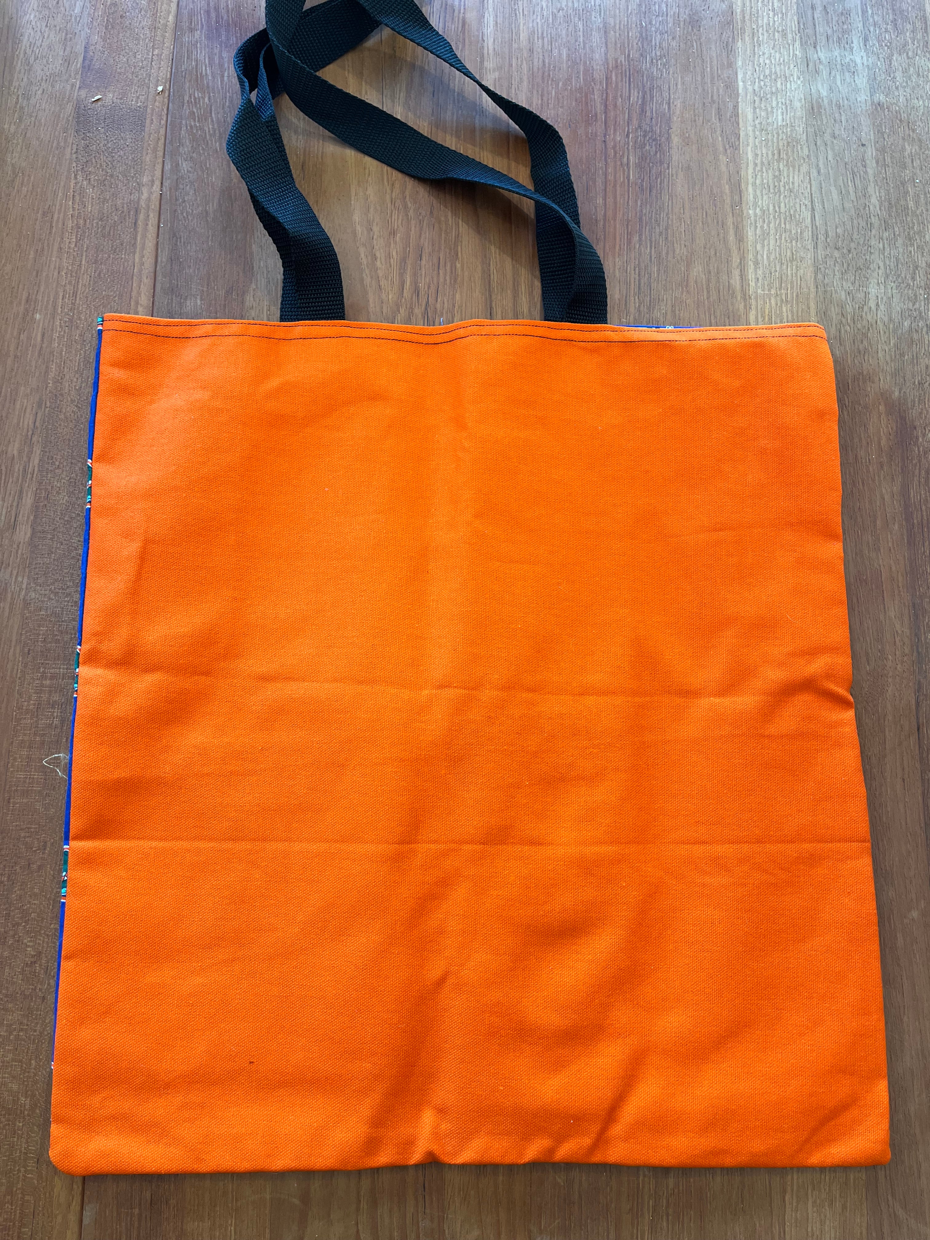 Solid orange back of the Gators print tote