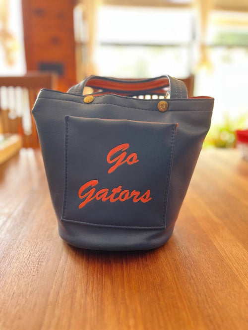Back of blue vinyl Gators purse with Go Gators script on pocket