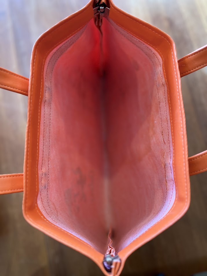 Inside orange vinyl Gators tote showing marbled lining and snap