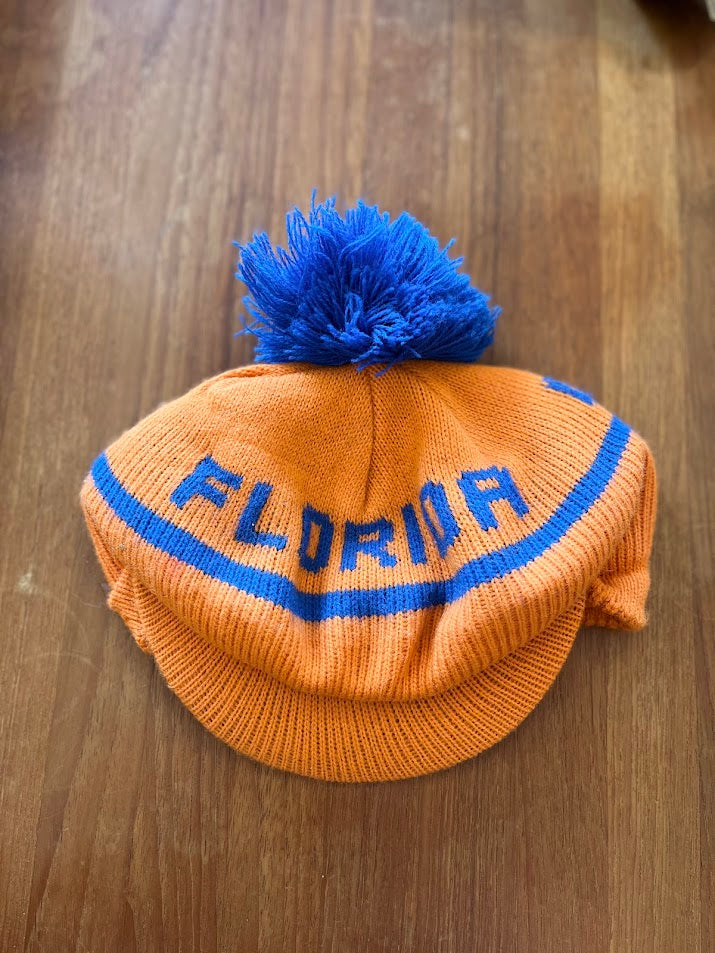Front of orange Gators knit beanie with blue pom and knit bill