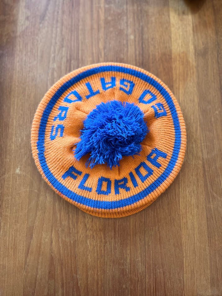 Orange Florida Gators knit beanie with blue pom, top view showing Go Gators lettering